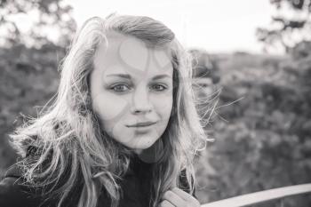 Outdoor closeup monochrome portrait of teenage Caucasian blond girl
