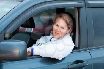 Young Caucasian woman as a driver, outdoor portrait in open car window