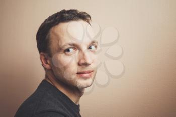 Young positive Caucasian man studio portrait over gray wall background, vintage tonal correction photo filter effect
