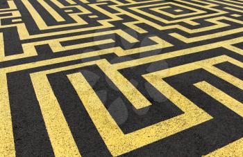 Yellow labyrinth painted on a black asphalt road 