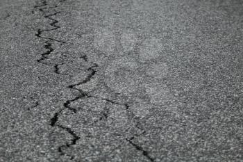 Closeup photo of cracks on old damaged asphalt road
