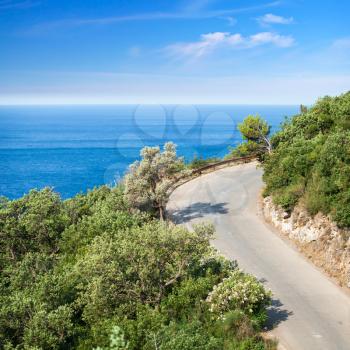 Mountain highway with blue sky and sea on a background