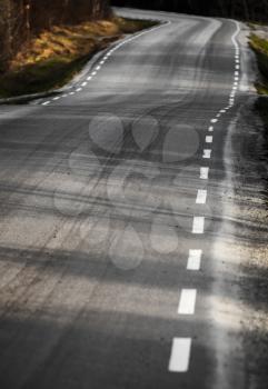 Curved rural asphalt road. Transportation photo background with shallow depth of field