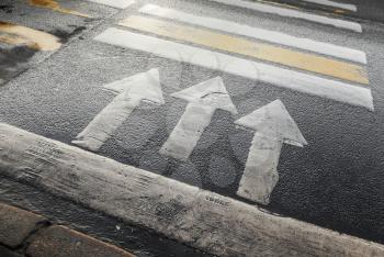 Pedestrian crossing road marking with arrows and lines on asphalt