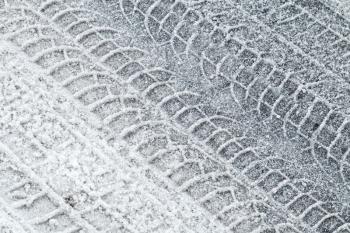 Background texture of road covered with snow and tire tracks