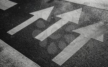 Pedestrian crossing road marking with white arrows on asphalt