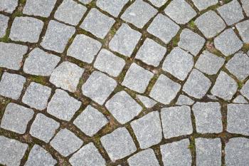Gray granite cobblestone pavement. Closeup background texture