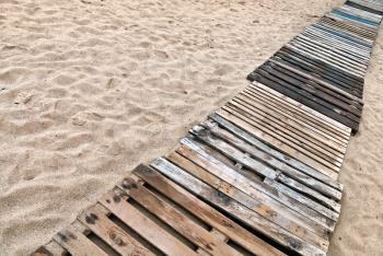 Wooden boards path on the sandy beach