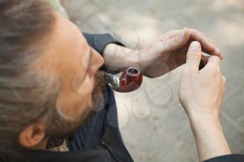 Man smoking pipe, outdoor photo with selective focus