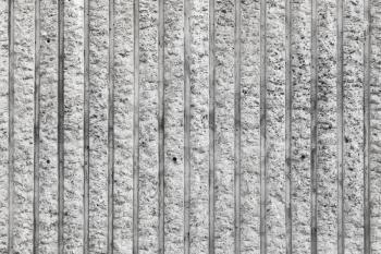 Rough gray concrete wall with vertical relief lines, frontal background photo texture