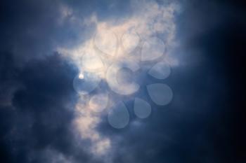 Dark stormy clouds with the Sun background texture