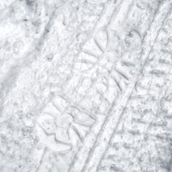 Footprint and tire tracks in the snow on the roadside