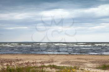 Baltic Sea in autumn. Coastal landscape with sandy beach under stormy sky 
