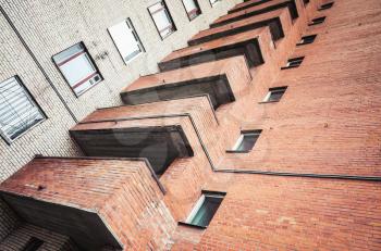 Abstract urban architecture fragment, gray and red brick walls with balconies and windows