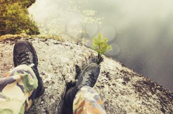 Soldier feet in camouflage pants and black rough shoes, modern army background. Vintage tonal correction photo filter, old style effect