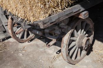 Fragment of an old rural wooden cart with hay
