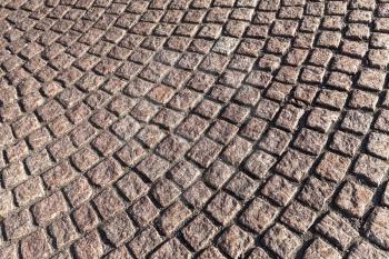 Brown cobblestone street pavement with round pattern, urban background texture