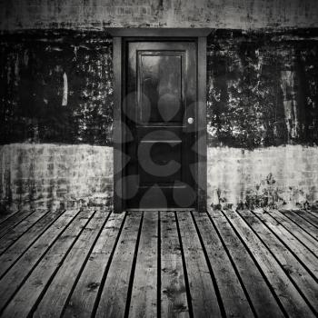Abstract empty dark room interior background with gray wooden floor and black door in concrete wall