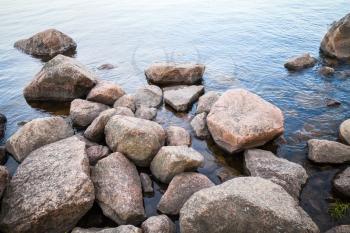Coastal granite stones lay in still lake water