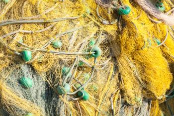 Yellow fishing net with green details drying on a pier, background photo