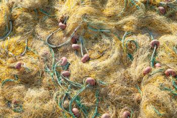 Yellow fishing net with green ropes drying on a pier, background photo