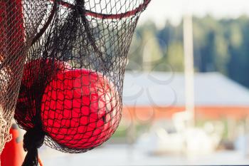 Fishing net fragment with red float sphere inside