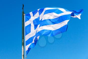 Flag of Greece waving on wind over clear blue sky background