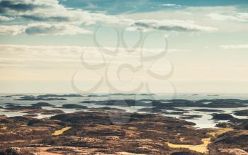 Norwegian coastal landscape, small rocky islands under blue sky. Vintage tonal correction photo filter, old style effect