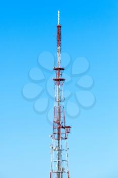 Telecommunication tower with radio devices over blue sky background