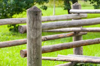 Rural wooden fence with green summer grass on a background