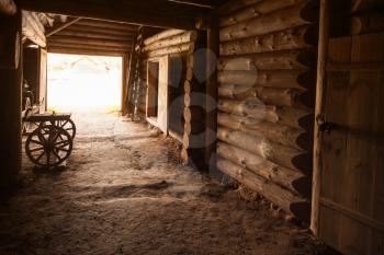 Ancient rural Russian interior. Corridor with walls made of rough logs and closed door in the end