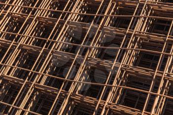 Abstract industrial background with stacked rusted reinforcing mesh, photo with selective focus