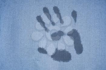 Wet handprint on rough frozen blue fabric surface