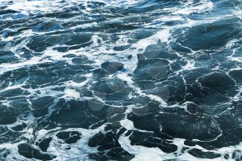 Deep blue stormy sea water surface with foam and waves pattern, natural background photo
