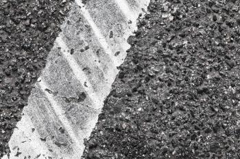 Rough dividing line fragment with tire tracks, highway road marking. Abstract transportation background