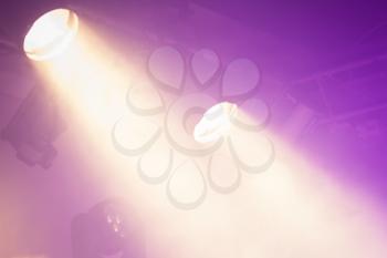 Powerful spot lights on purple background, stage illumination