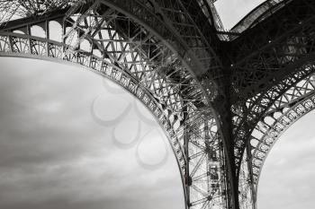 Arch of  the Eiffel tower bearings, the most popular landmark of Paris, France. Monochrome photo with retro style effect