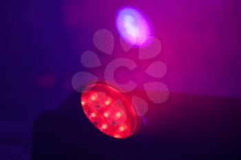 Closeup photo of bright LED spot light with red beam, stage illumination equipment