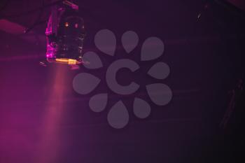 Scenic spot light beam over dark purple background, stage illumination equipment
