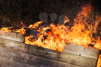 Closeup photo of burning wooden boxes in big bonfire