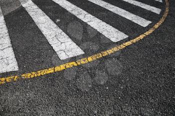Pedestrian crossing road marking zebra, white stripes and yellow border line over black asphalt pavement, background photo