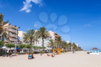 Wide public sandy beach of Calafell resort town in a sunny summer day. Tarragona region, Catalonia, Spain