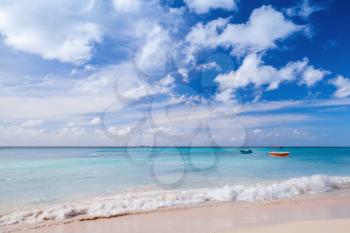 Tropical beach background, white coastal sand, azure water under cloudy blue sky. Caribbean Sea coast, Dominican republic, Saona island
