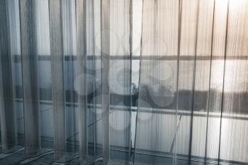 Tulle curtain with waving pattern over wide window. Background photo texture