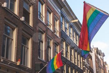 Rainbow flags representing LGBT pride mounted on house facade in Amsterdam