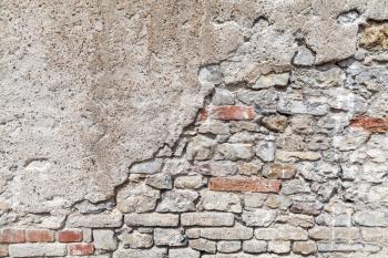 Old brick wall with damaged concrete stucco layer, flat background photo texture