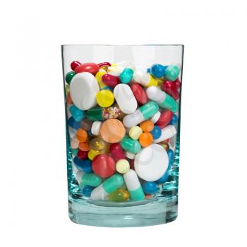 Medical cocktail - glass full of pills. Isolated