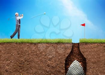 Businessman is hitting the golf ball to the hole with huge heap of ball in there
