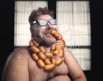 Happy bearded man eating sausages from his neck