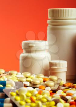 Colorful pills, capsules, dragee and white bottles
